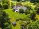 An aerial view displays a well-kept property with a lush yard, deck, and tranquil surroundings at 3619 Nc-57, Hillsborough, NC 27278