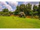 Spacious backyard with a storage shed, mature trees, and lovely landscaping at 3619 Nc-57, Hillsborough, NC 27278