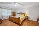 Comfortable bedroom with a wooden bed frame, hardwood floors, and a large window at 3619 Nc-57, Hillsborough, NC 27278