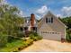Home exterior with a two-car garage and driveway, lush greenery, and a well-maintained lawn at 3619 Nc-57, Hillsborough, NC 27278