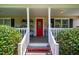 Charming covered front porch with a bright red front door and white railing at 3619 Nc-57, Hillsborough, NC 27278