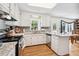 Bright kitchen with white cabinets, granite countertops, stainless steel appliances, and a window over the sink at 3619 Nc-57, Hillsborough, NC 27278