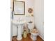 Cozy powder room with pedestal sink, decorative mirror, and a charming floral theme at 3619 Nc-57, Hillsborough, NC 27278