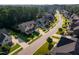 Aerial view of a residential street featuring well-maintained homes, green lawns, and mature trees at 3624 Regent Pines Dr, New Hill, NC 27562