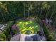 Stunning aerial view of a backyard with manicured lawn, landscaped garden, and outdoor fire pit at 3624 Regent Pines Dr, New Hill, NC 27562