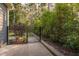 Backyard showing a black metal gate that leads to an expansive lawn and surrounding greenery at 3624 Regent Pines Dr, New Hill, NC 27562