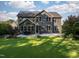 Expansive backyard with patio area, fire pit, mature trees, and beautifully landscaped gardens at 3624 Regent Pines Dr, New Hill, NC 27562