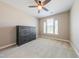 Cozy bedroom featuring a ceiling fan, neutral carpet and paint, and a dark wood dresser at 3624 Regent Pines Dr, New Hill, NC 27562