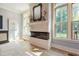 Bright living room fireplace with electric firebox, white mantle, mirror and lots of natural light at 3624 Regent Pines Dr, New Hill, NC 27562