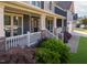Charming covered front porch with classic white railings, brick details, and lush landscaping at 3624 Regent Pines Dr, New Hill, NC 27562