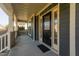 Inviting front porch with stylish columns, a black front door with decorative glass, and dark siding at 3624 Regent Pines Dr, New Hill, NC 27562