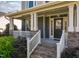 Welcoming front porch with brick stairs, white railings, decorative columns, and well-maintained landscaping at 3624 Regent Pines Dr, New Hill, NC 27562