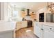 Bright kitchen featuring stainless appliances, white cabinets, stone countertops and floating shelves at 3624 Regent Pines Dr, New Hill, NC 27562
