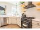 Bright kitchen featuring stainless appliances, white cabinets, stone countertops and floating shelves at 3624 Regent Pines Dr, New Hill, NC 27562