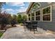 Outdoor patio with a bar-height table and chairs, set against the home's exterior with large windows at 3624 Regent Pines Dr, New Hill, NC 27562