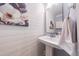 Chic powder room with shiplap walls, pedestal sink, and stylish art, adding elegance at 3624 Regent Pines Dr, New Hill, NC 27562