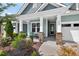 Welcoming front porch with stone columns, stylish seating, and beautiful landscaping at 365 Middleton Pl, Chapel Hill, NC 27516