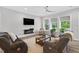 Bright living room with a modern fireplace, TV, and large windows with a view of the backyard at 365 Middleton Pl, Chapel Hill, NC 27516