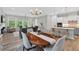 Open-concept living space with kitchen island, dining area, and living room with large windows overlooking trees at 365 Middleton Pl, Chapel Hill, NC 27516