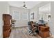 A well-lit home office with desk, shelves, chair, and large windows, perfect for remote work at 365 Middleton Pl, Chapel Hill, NC 27516