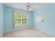 Cozy bedroom features a ceiling fan, natural light, neutral carpet, and pale-blue painted walls at 3812 Covina Dr, Raleigh, NC 27613