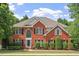 Beautiful two-story brick home with black shutters, manicured lawn, and lush landscaping at 3812 Covina Dr, Raleigh, NC 27613