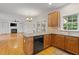 Open kitchen with island, stainless steel appliances, wood cabinets and living space at 3812 Covina Dr, Raleigh, NC 27613