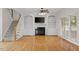 Inviting living room with fireplace, built-in shelving, large windows, and hardwood floors at 3812 Covina Dr, Raleigh, NC 27613