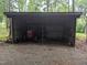 Equipment storage with tractor, farm implements, and gravel floor surrounded by trees at 4008 Old Nc 86, Hillsborough, NC 27278