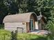 Unique barrel-roofed tiny home with wood siding and deck nestled in a lush, green forest setting at 4008 Old Nc 86, Hillsborough, NC 27278