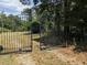 Gated entrance providing security and privacy, framed by mature trees and natural surroundings at 4008 Old Nc 86, Hillsborough, NC 27278