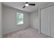 Neutral bedroom featuring a ceiling fan, closet, and window overlooking a grassy lawn at 403 Carpenter Fletcher Rd, Durham, NC 27713