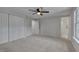 Main bedroom featuring a ceiling fan, closet, ensuite bathroom, and window overlooking a green lawn at 403 Carpenter Fletcher Rd, Durham, NC 27713