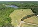 A vast field with sparse trees and a distant lake, offering tranquility and natural beauty at 404 Blooming Meadows Rd, Holly Springs, NC 27540