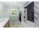 Stylish bathroom featuring modern fixtures, a soaking tub with a shower, and decorative tile accents for a luxurious feel at 404 Blooming Meadows Rd, Holly Springs, NC 27540