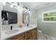 Modern bathroom with double sink vanity, mirrors, quartz countertop, and decorative lighting at 404 Blooming Meadows Rd, Holly Springs, NC 27540