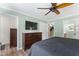 A bedroom with a TV, dresser, and access to a walk-in closet and staircase at 404 Blooming Meadows Rd, Holly Springs, NC 27540