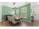 Bright dining area with a large table, a modern chandelier, and windows providing natural light and neighborhood views at 404 Blooming Meadows Rd, Holly Springs, NC 27540