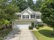 Charming two-story home with a well-manicured lawn, attached two-car garage, and mature trees in a lovely neighborhood at 404 Blooming Meadows Rd, Holly Springs, NC 27540