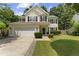 Charming two-story home with a well-manicured lawn, inviting front entrance, and attached garage at 404 Blooming Meadows Rd, Holly Springs, NC 27540