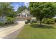 Inviting two-story home with a classic facade, lush landscaping, and a spacious driveway at 404 Blooming Meadows Rd, Holly Springs, NC 27540