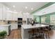 Modern kitchen with stainless steel appliances, a large island, and white cabinets and an eat-in dining area at 404 Blooming Meadows Rd, Holly Springs, NC 27540
