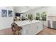 Kitchen island with white countertops, barstools, and stainless steel appliances in an open-concept living space at 404 Blooming Meadows Rd, Holly Springs, NC 27540