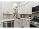 Well-lit kitchen featuring white cabinetry, stainless steel appliances, and stone backsplash at 404 Blooming Meadows Rd, Holly Springs, NC 27540
