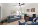 Comfortable living room with a blue sofa, fan, and colorful artwork for a cozy vibe at 404 Blooming Meadows Rd, Holly Springs, NC 27540
