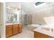Bathroom featuring double sinks, tile flooring, and a skylight above a bathtub and shower at 4060 Barton Park Pl, Raleigh, NC 27613