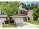 Attractive brick townhome boasting a two-car garage, manicured lawn, and lovely curb appeal at 4060 Barton Park Pl, Raleigh, NC 27613