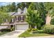 Beautiful brick townhome with a two-car garage, complemented by lush landscaping and mature trees at 4060 Barton Park Pl, Raleigh, NC 27613
