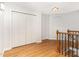 Hallway with hardwood floors, closet storage, and staircase with wooden railing at 4060 Barton Park Pl, Raleigh, NC 27613