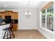 Open kitchen area with wood cabinets, black countertops, and natural light from a window at 4060 Barton Park Pl, Raleigh, NC 27613